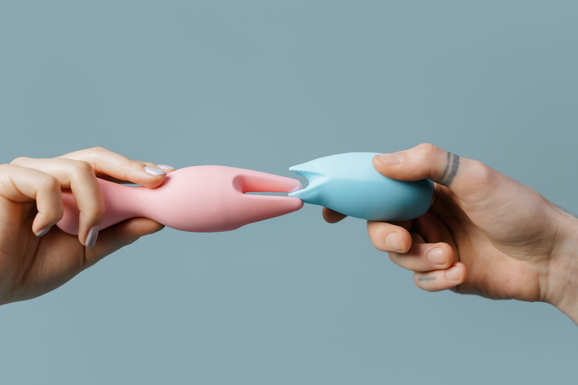Hand holding a vibrator against a minimalist purple backdrop, symbolizing personal pleasure and self-care