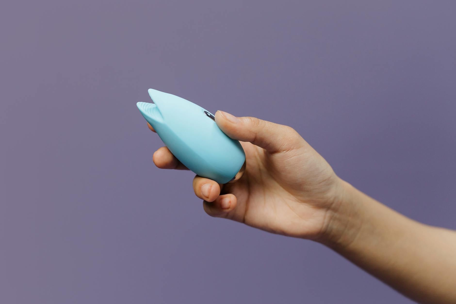 Close-up of a blue silicone vibrator held in hand, symbolizing self-care and intimate reconnection