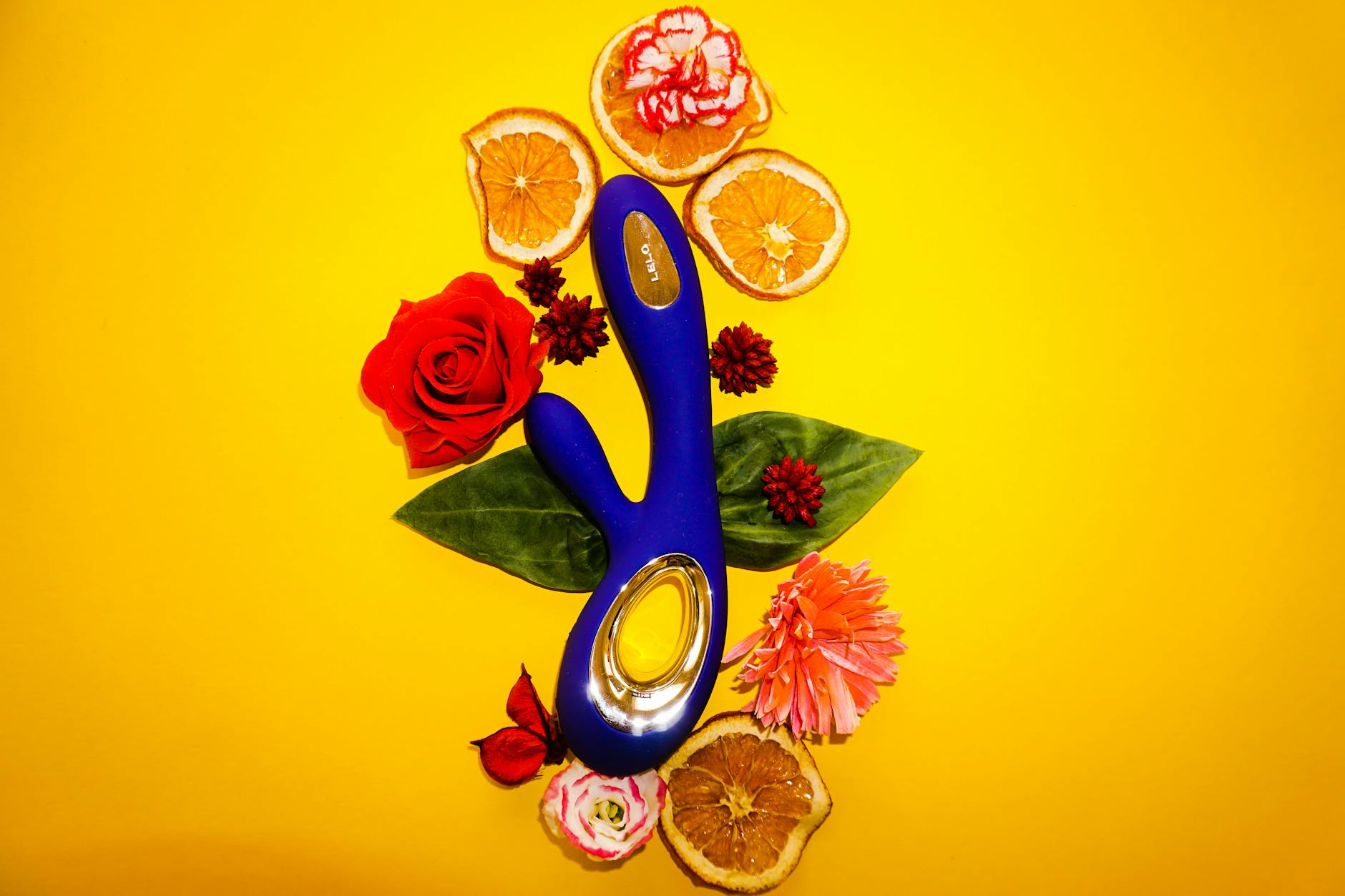 Hand hält einen eleganten blauen Saugvibrator gegen lila Hintergrund