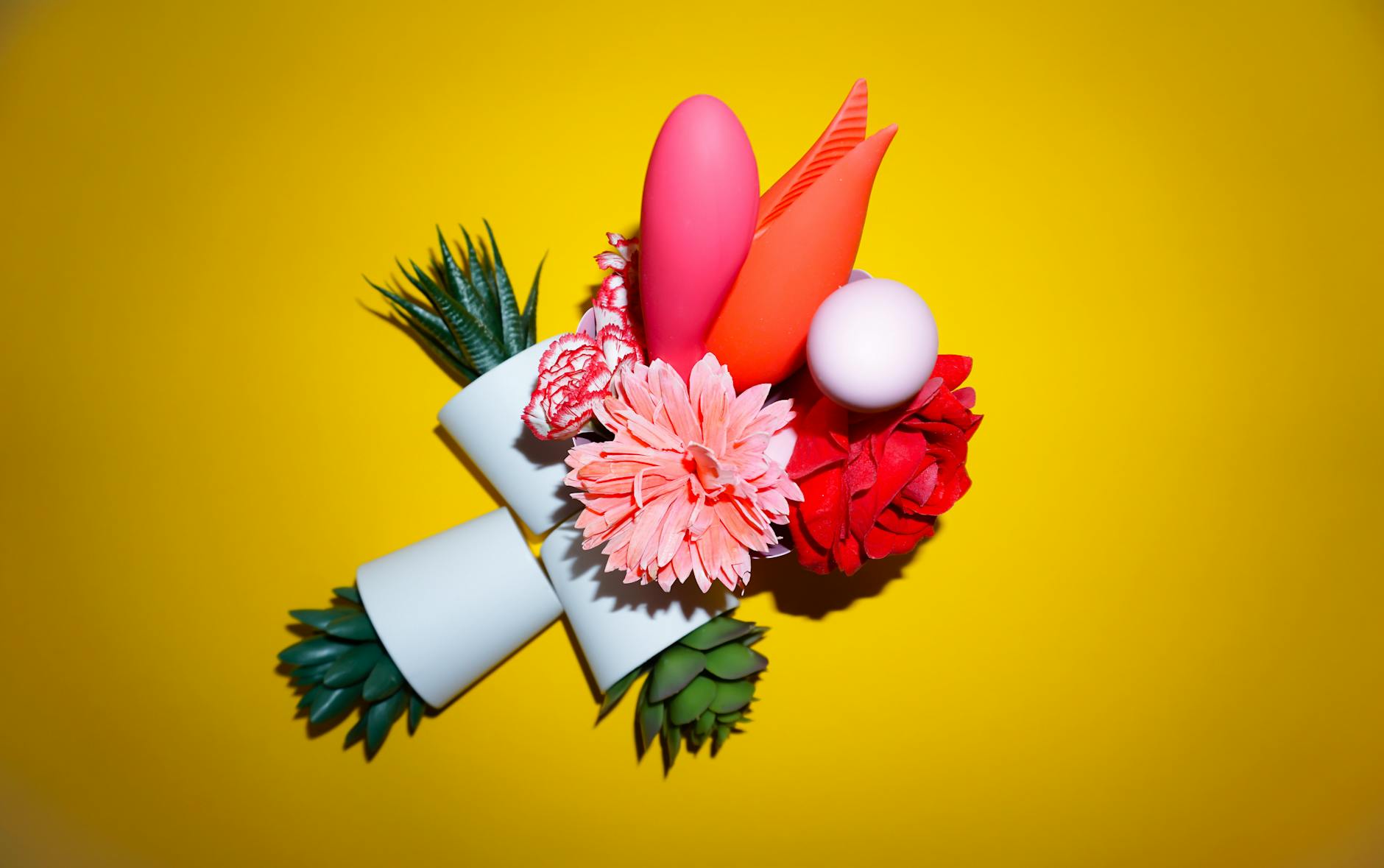 Eine Person hält einen Korb mit bunten Vibratoren und einer rosa Blume, was Vergnügen und Selbstliebe symbolisiert